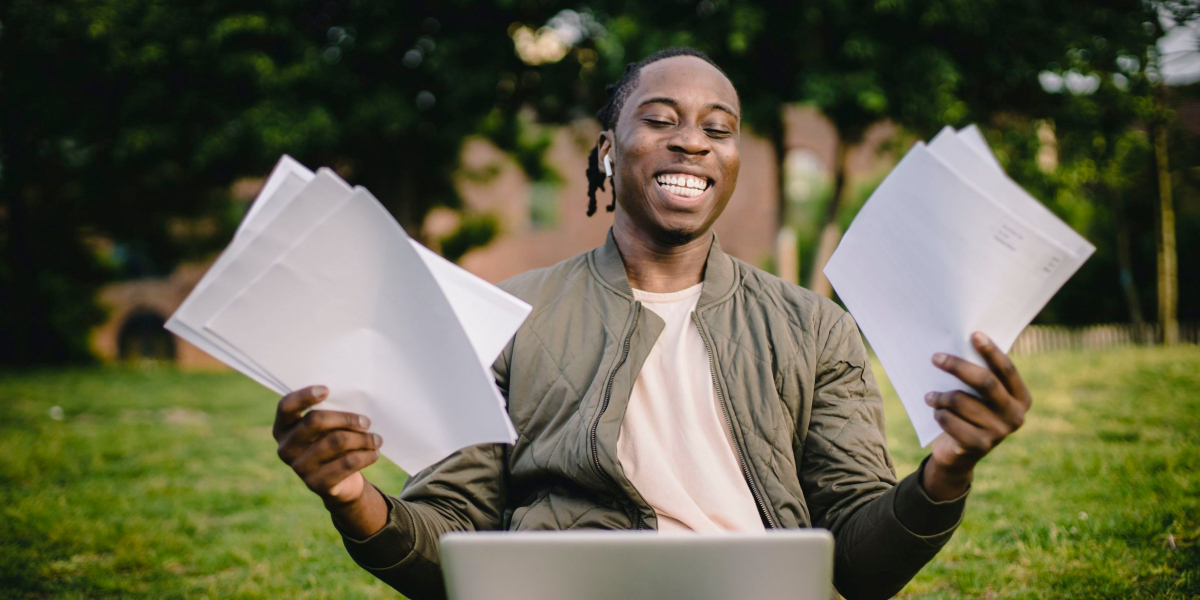 man smiling and holding papers